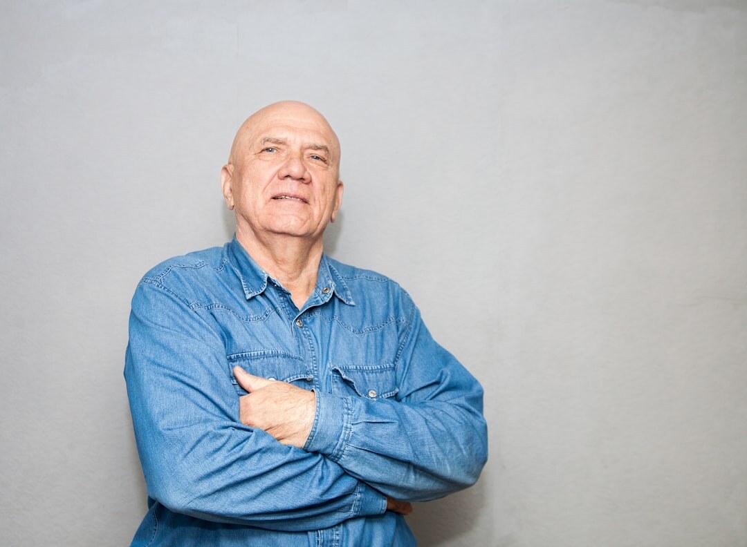 Studio portrait of a friendly senior Croatian man volunteer coordinator